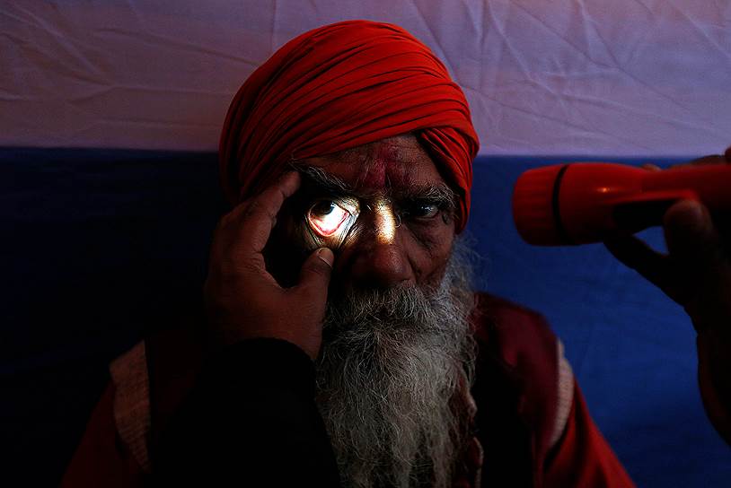 Калькутта, Индия. Мужчина проходит медобследование в лагере офтальмологической помощи, организованном социальными работниками, перед поездкой на остров Сагар на фестиваль «Макар Санкранти»