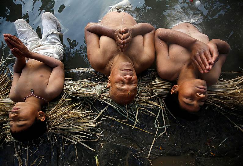 Бхактапур, Непал. Монахи молятся во время купания в реке Хануманте