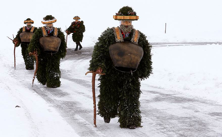 Урнеш, Швейцария. Мужчины, одетые в традиционные костюмы для отпугивания злых сил, во время традиционного шествия Sylvesterchlausen