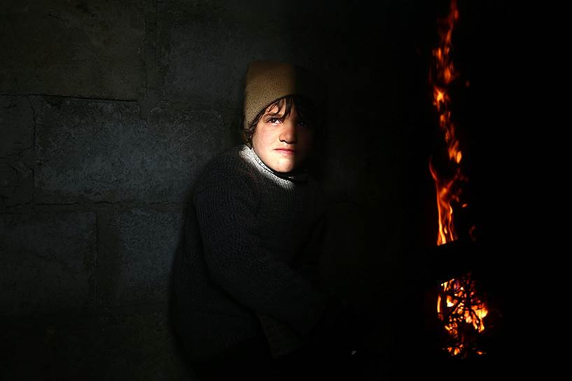 Дамаск, Сирия. Мальчик смотрит на пожар в подконтрольном оппозиции районе города