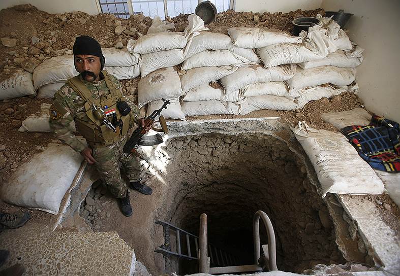 Мосул, Ирак. Иракский военный стоит у тоннеля, который боевики «Исламского государства» использовали, чтобы бежать из города 