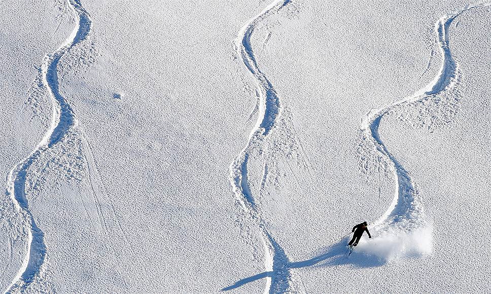 Альпы, Швейцария. Лыжник спускается по заснеженному склону 