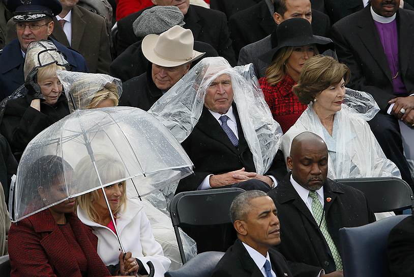 Бывший президент США Джордж Буш-младший укрывается от дождя