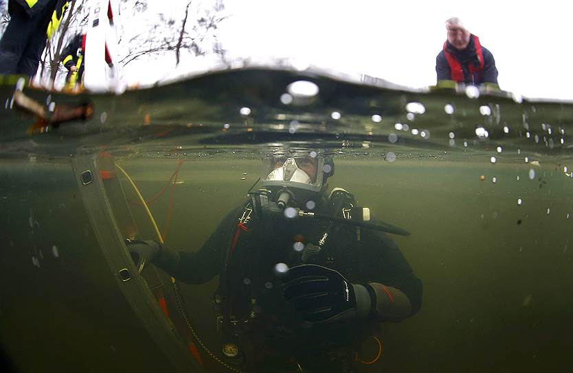 Франкфурт-на-Майне, Германия. Сотрудник спасательной службы погружается в замерзшее озеро во время учений