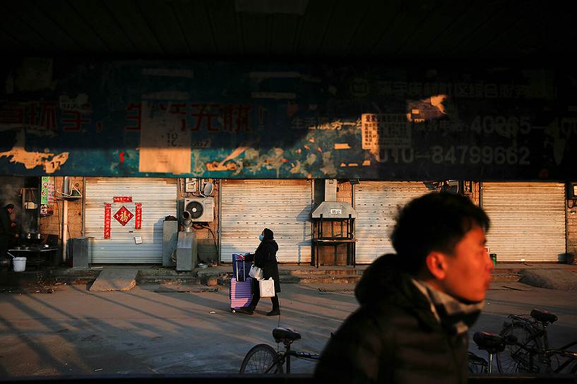 Пекин, Китай. Женщина с чемоданом перед отъездом на выходные, посвященные Китайскому Новому году