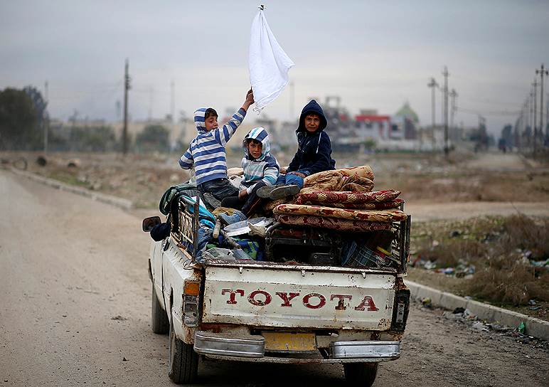 Мосул, Ирак. Дети держат белый флаг во время проезда через линию фронта между иракскими военными и террористами «Исламского государства»
