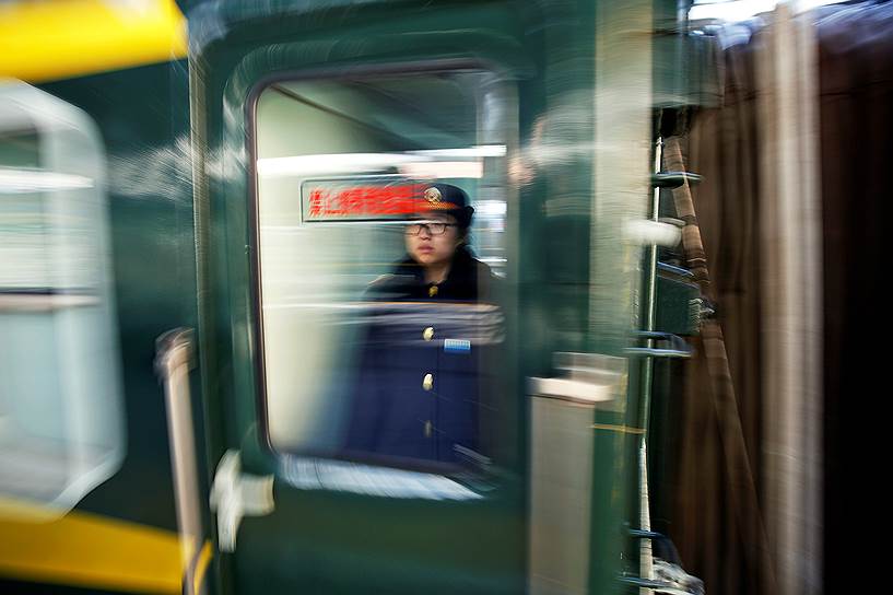 Пекин, Китай. Работник метрополитена во время отправления поезда