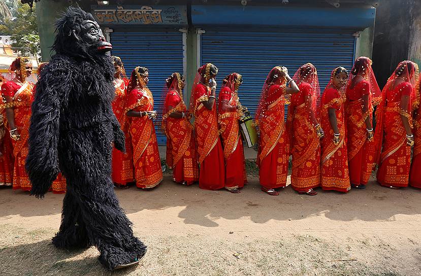 Баиркхенд, Индия. Актер в костюме шимпанзе перед очередью невест на массовой свадьбе, во время которой будут сочетаться барком 109 пар