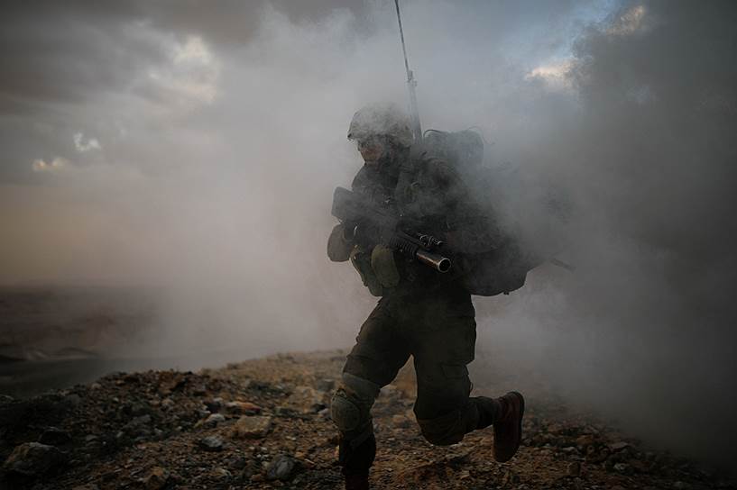 Арад, Израиль. Служащий стрелковой бригады бежит сквозь дым от шашки во время учений