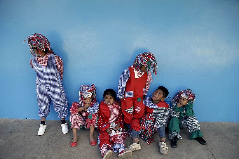 Бокете, Панама. Дети, одетые в костюмы клоунов, ждут своей очереди исполнить танец перед лауреатом Нобелевской премии мира Кайлашом Сатьяртхи во время его визита в школу для детей из бедных семей