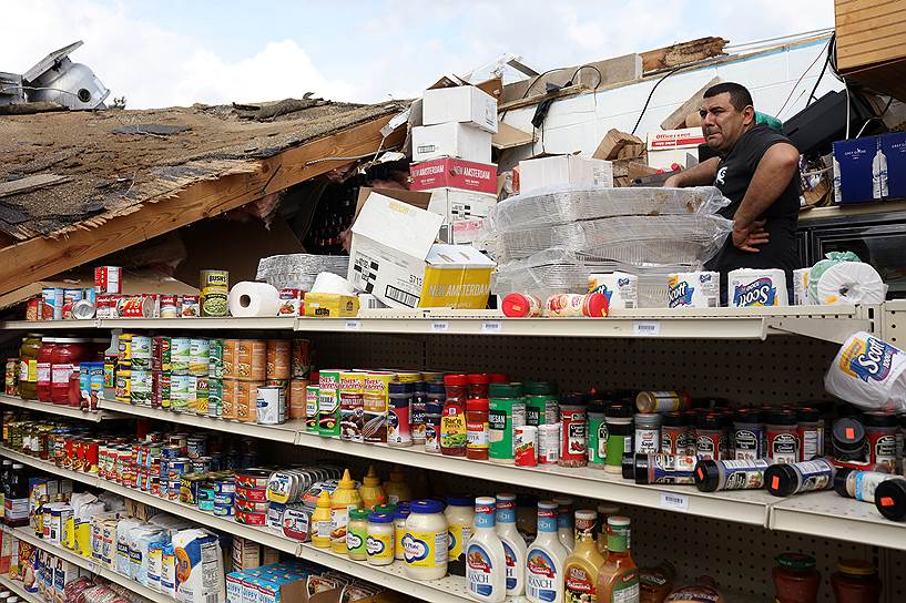 Новый Орлеан, США. Хозяин разрушенного торнадо магазина смотрит на оставшийся товар. Жертвами стихии стали десятки человек, около 10 тыс. домов остались без электричества