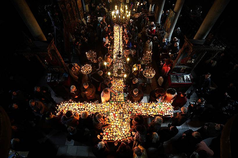 Благоевград, Болгария. Посетители храма у столов со свечами и медом в день покровителя пчеловодов