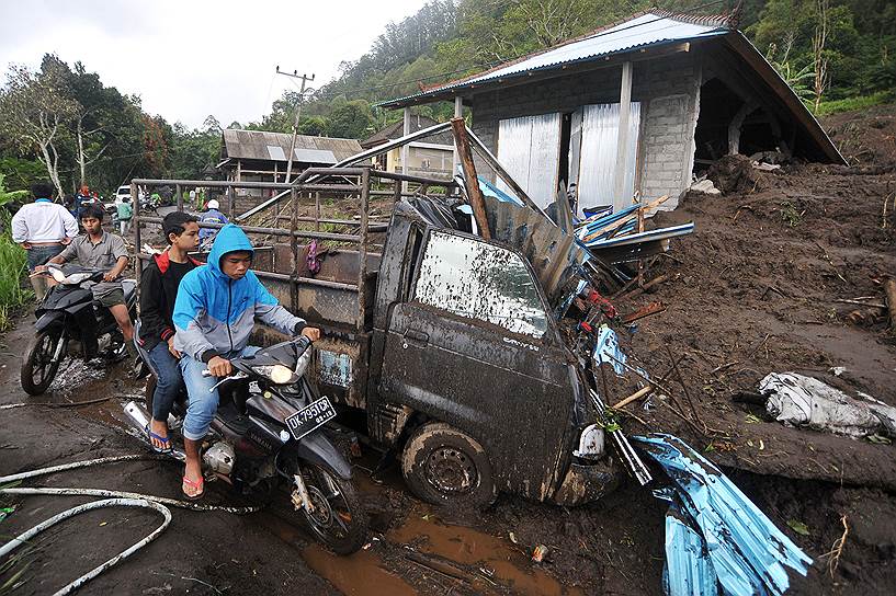 Кинтамани, Индонезия. Мотоциклисты у разрушенного оползнем дома. Жертвами стихийного бедствия стали 12 человек