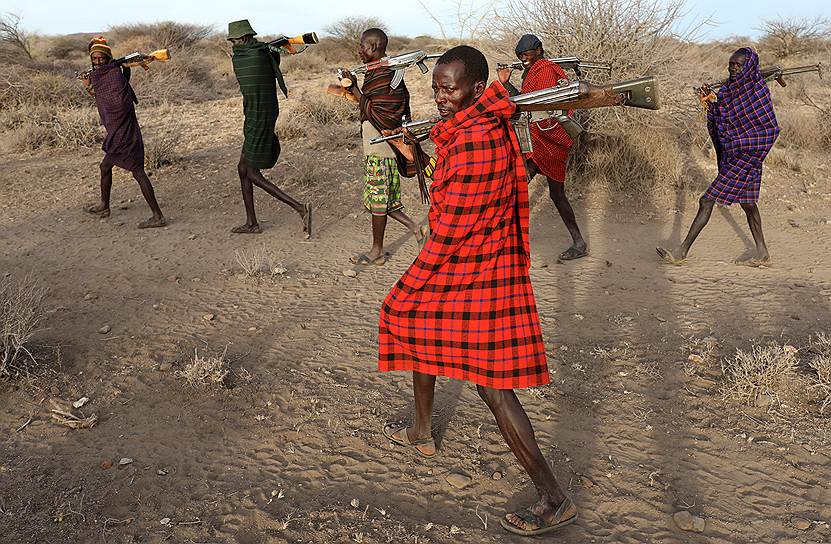 Барагой, Кения. Мужчины одного из племен несут оружие, чтобы отбиваться от представителей других племен, которые воруют скот 