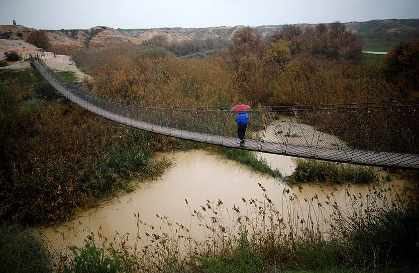 Пустыня Негев, Израиль. Мужчина переходит через ручей, вода в котором поднялась после ливней