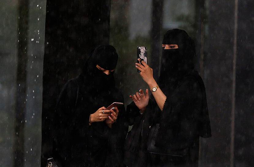 Эр-Рияд, Саудовская Аравия. Женщины фотографируют дождь 