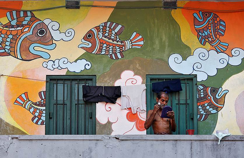 Калькутта, Индия. Мужчина бреется на балконе своего дома