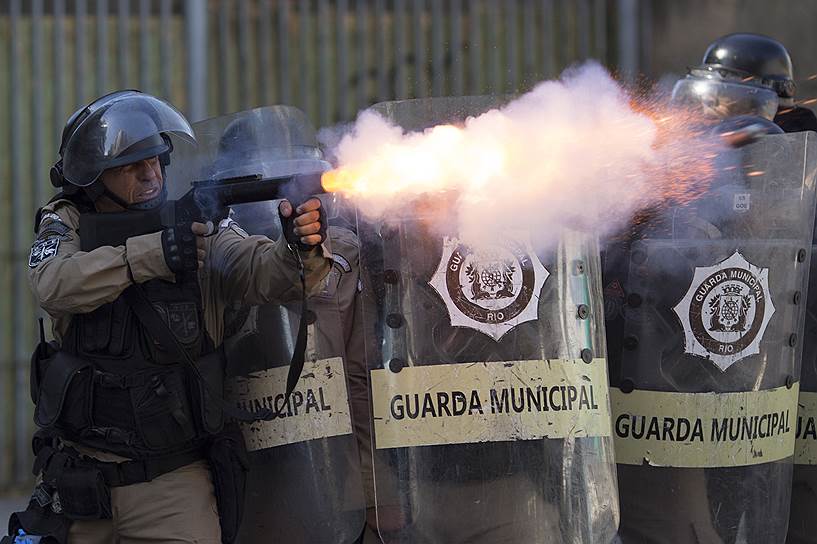 Рио-де-Жанейро, Бразилия. Полицейские распыляют слезоточивый газ во время демонстрации против приватизации городской компании-оператора коммунальных услуг