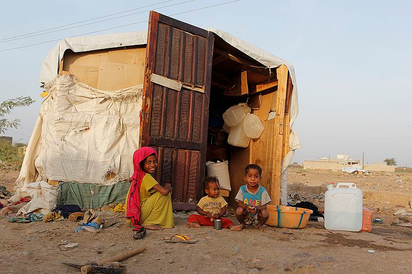 Ходейда, Йемен. Дети сидят рядом со своей хижиной в импровизированном лагере для вынужденных переселенцев