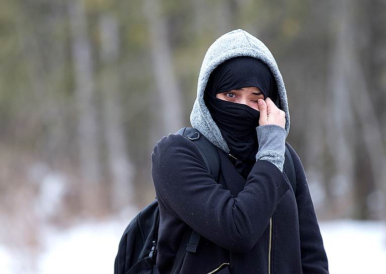 Женщина из Йемена вытирает слезы после того, как ей запретили въезд в Канаду