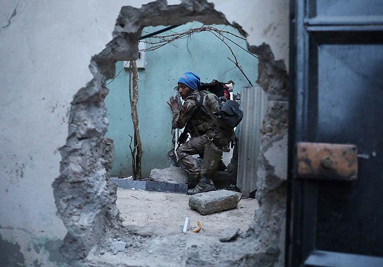 Мосул, Ирак. Иракский солдат пролезает через дыру в стене во время операции по вытеснению террористов «Исламского государства» из провинции