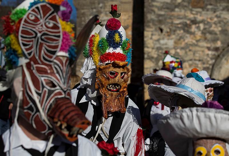 Альмируэте, Испания. Одетые в костюмы монстров местные жители идут по улице 