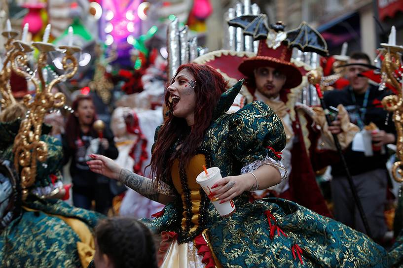 Валлетта, Мальта. Танцующая участница карнавала с напитком в руке 