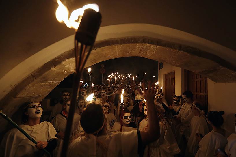 Наксос, Греция. Одетые в черно-белую одежду участники парада факелов 