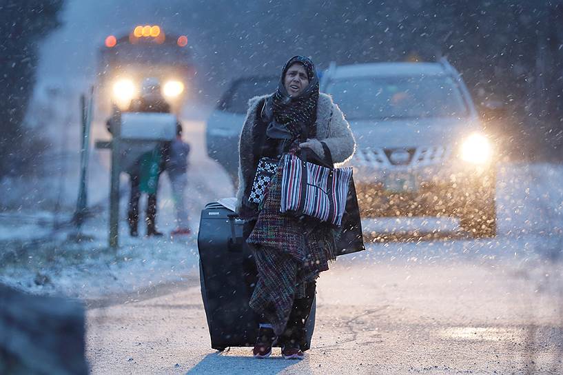 Амэнжфор, Канада. Женщина пересекает границу Канады и США. Поток мигрантов между двумя странами увеличился после того, как президент Дональд Трамп издал указ о запрете въезда в страну выходцев с Ближнего Востока
