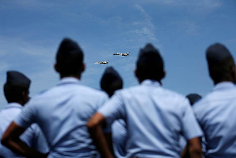 Коломбо, Шри-Ланка. Участники парада в честь дня военно-воздушных сил страны смотрят вступление пилотажной группы 