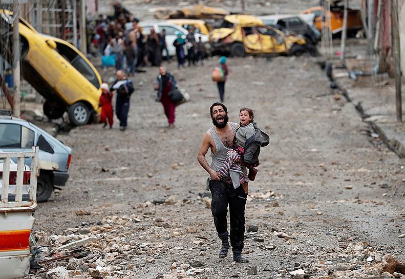 Мосул, Ирак. Мужчина с дочерью бежит к правительственным войскам из части города, контролируемой террористами «Исламского государства» (запрещено в РФ)