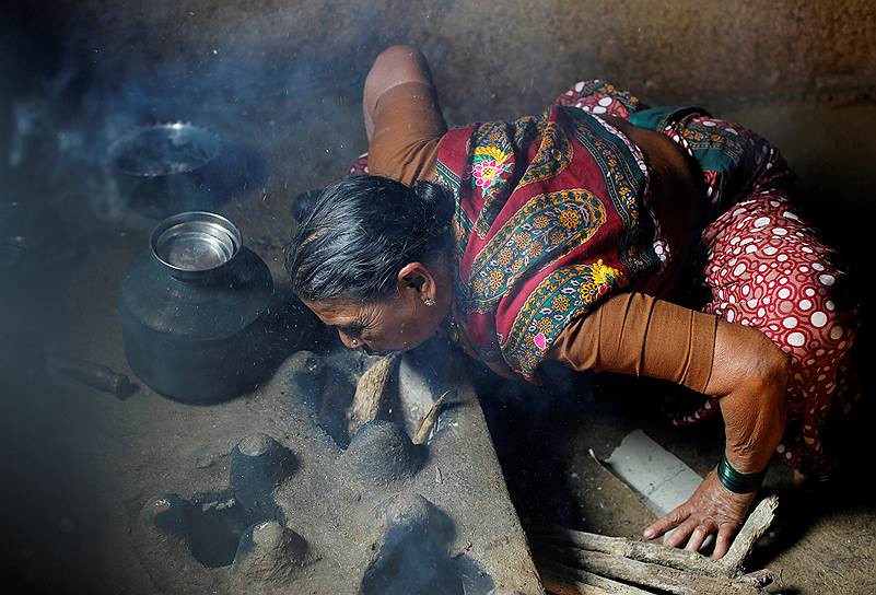 Ученица школы Aajibaichi Shaala разжигает огонь у себя дома, чтобы приготовить еду перед занятиями