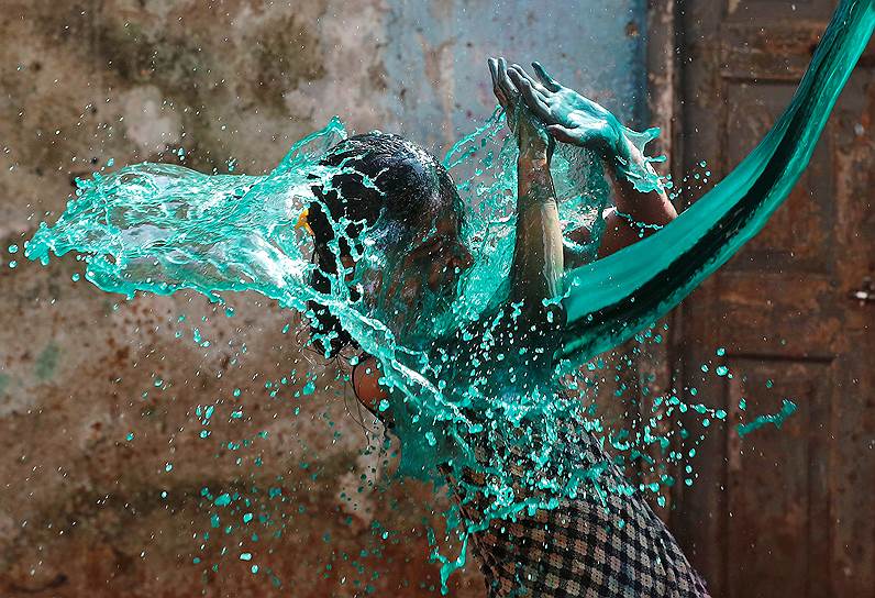 Мумбаи, Индия. Девочка во время праздника весны Холи, когда участники осыпают друг друга цветным порошком и обливаются водой с красками 