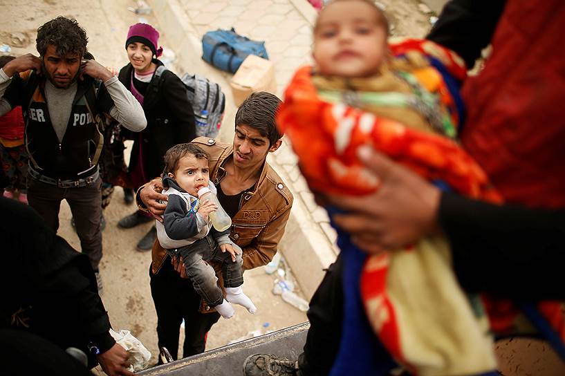 Мосул, Ирак. Местные жители грузят детей в машину для эвакуации из районов, где идут бои с террористами «Исламского государства»
