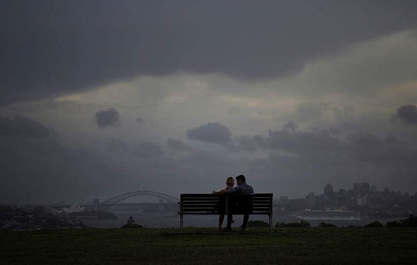Сидней, Австралия. Пара смотрит на ливень над городом