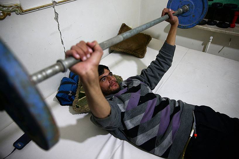 24-летний Айман, который получил травму позвоночника, разминает руки в рамках курса по реабилитации