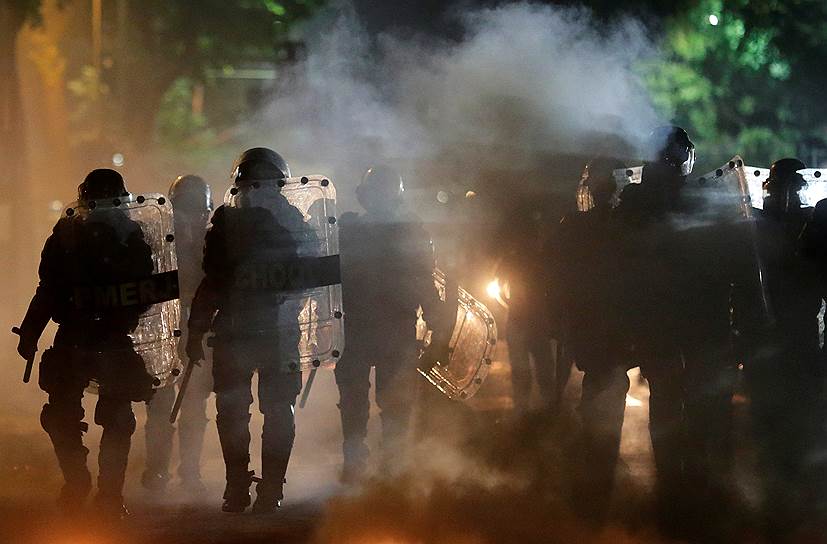 Рио-де-Жанейро, Бразилия. Полицейские на фоне горящих баррикад, которые соорудили участники антиправительственных протестов