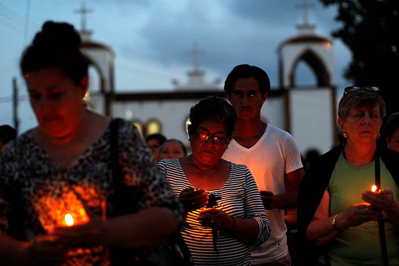 Пальмас де Абахо, Мексика. Женщины, чьи дети пропали без вести, идут из храма после того, как полиция обнаружила массовое захоронение 250 человек. По данным правоохранителей, молодые люди и девушки стали жертвами преступной группировки в штате Веракрус