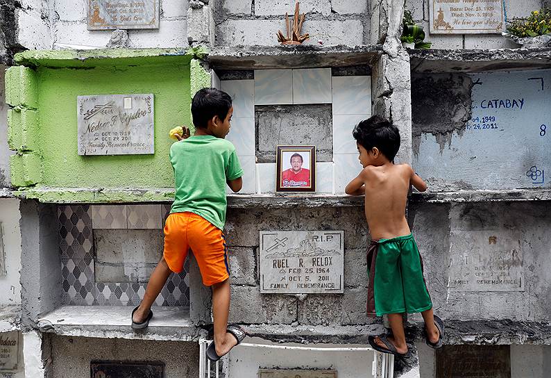 Манила, Филиппины. Мальчики смотрят на могилу мужчины, который стал жертвой нарковойны в стране