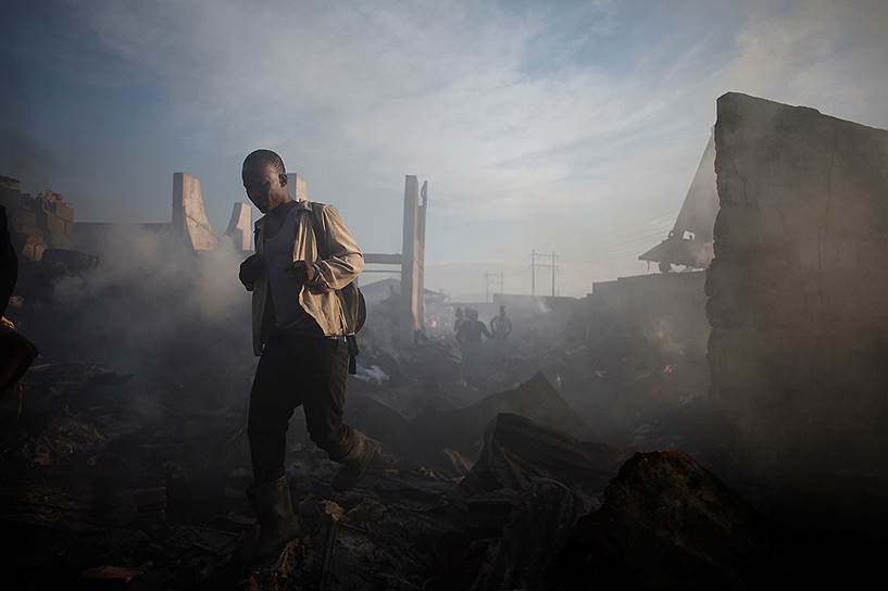 Порт-о-Пренс, Гаити. Мужчина идет по руинам сгоревшего рынка