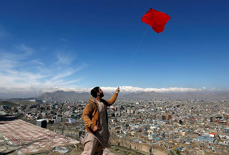 Кабул, Афганистан. Мужчина запускает воздушного змея на вершине холма