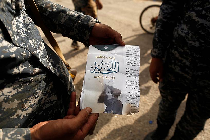 Иракский солдат показывает листовку, найденную в городе Аль-Шура. Надпись гласит: «Ношение бород является обязательным, бритье запрещено»