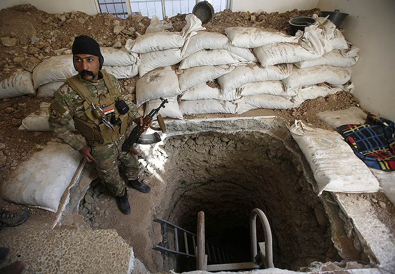 Иракский военнослужащий стоит у входа в туннель, вырытый исламистами