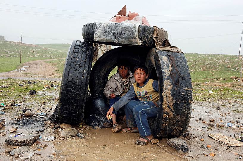 Мосул, Ирак. Иракские дети пытаются укрыться от дождя