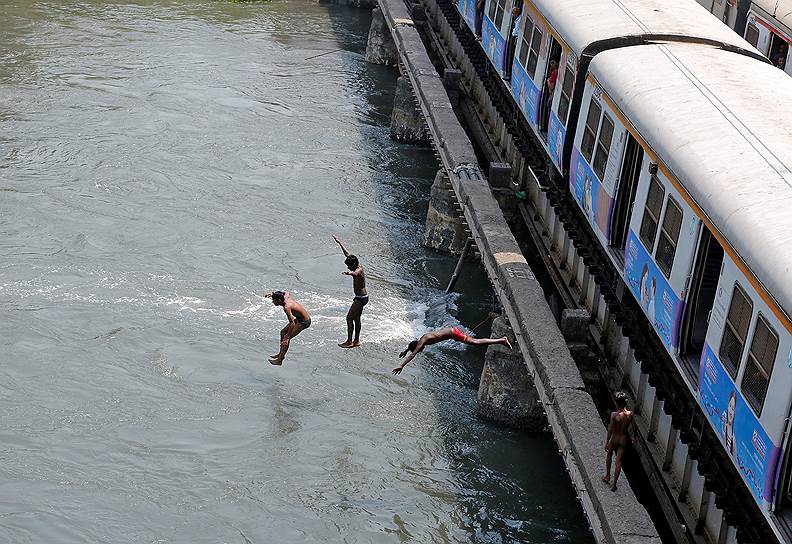 Мумбаий, Индия. Дети прыгают с железнодорожного моста в воду