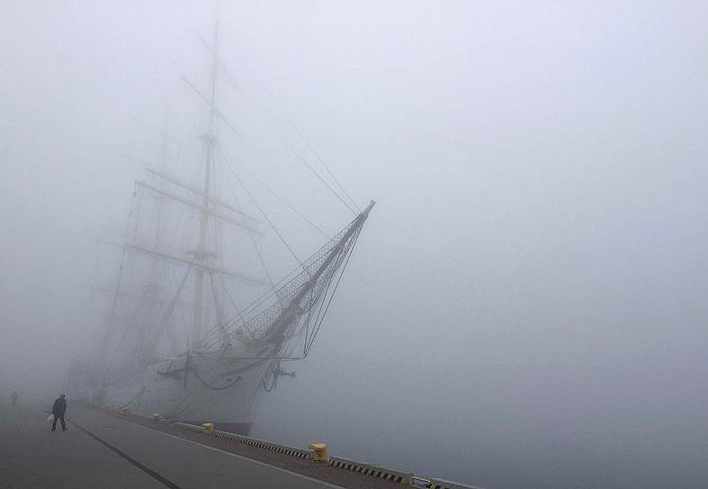Гдыня, Польша. Мужчина идет мимо корабля-музея «Дар Поморья», окутанного туманом 