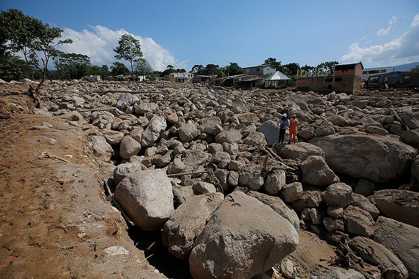 Мокоа, Колумбия. Спасатели ищут жертв наводнения среди камней, которые вынесла на дорогу вышедшая из берегов река