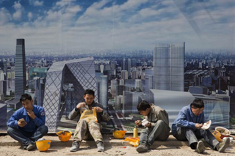 Пекин, Китай. Рабочие во время обеденного перерыва в деловом районе города