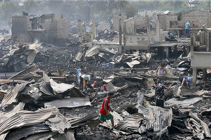 Бакоор, Филиппины. Местные жители в разрушенном пожаром районе города. По официальным данным, огонь уничтожил около 600 домов, более тысячи человек остались без крова