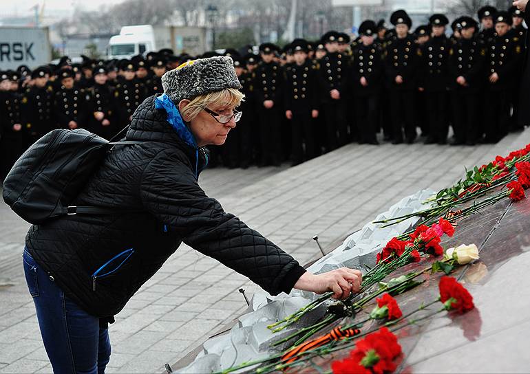 Женщина возлагает цветы к мемориалу на Корабельной набережной во Владивостоке в память о жертвах теракта в Санкт-Петербурге